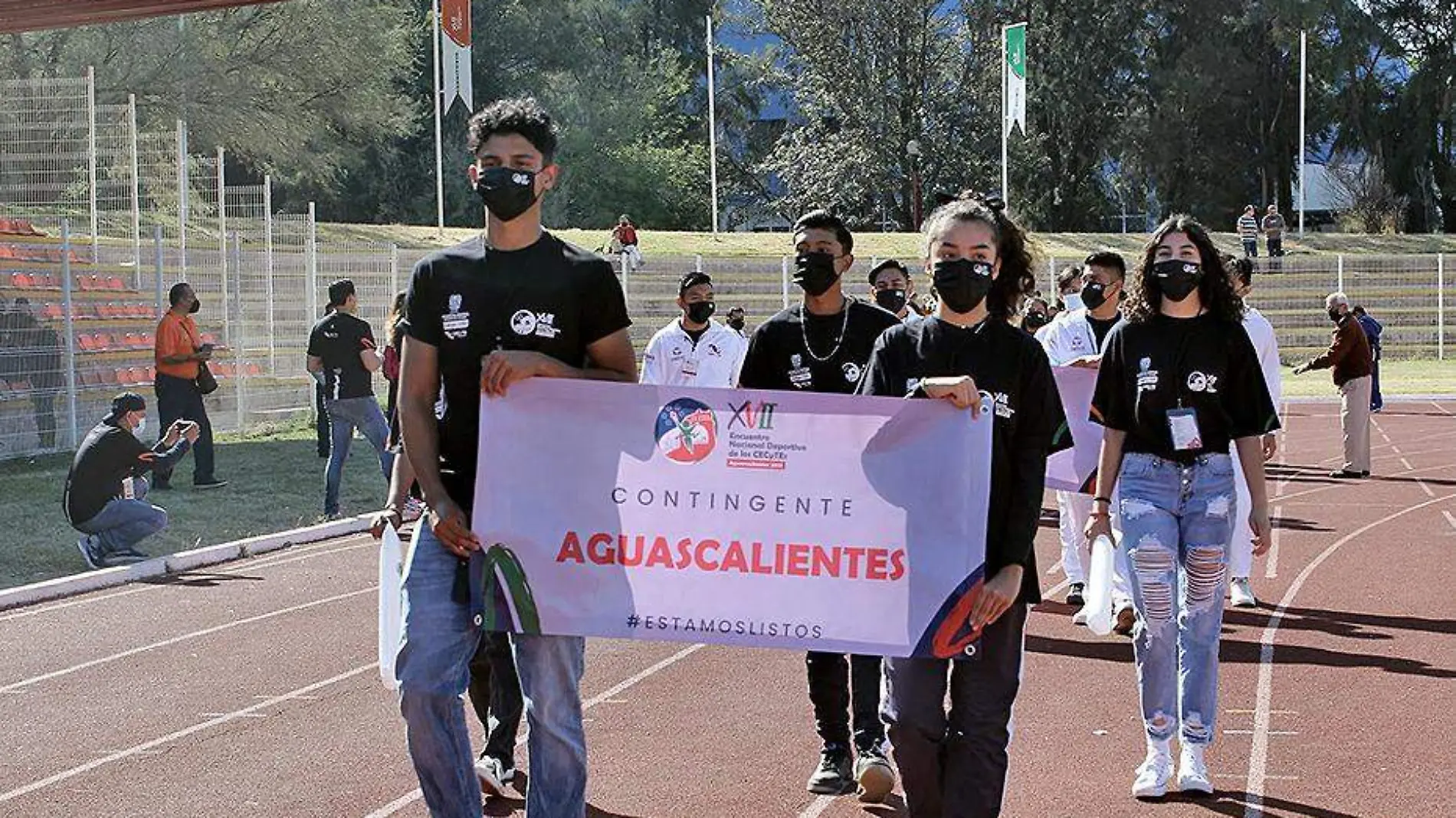 estudiantes desfilan en evento deportivo